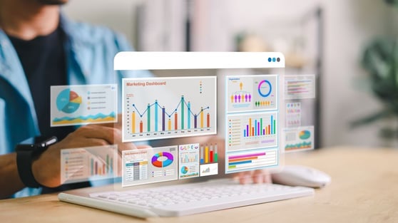 Marketing analytics dashboard with charts and graphs displayed on a transparent screen over a laptop.