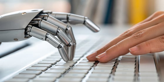 A close-up of a robot hand and a human finger interacting on a keyboard, symbolizing collaboration between AI and human writing.