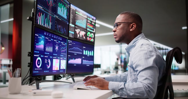 Marketer reviewing multiple analytics screens for AI-powered insights and real-time optimization.