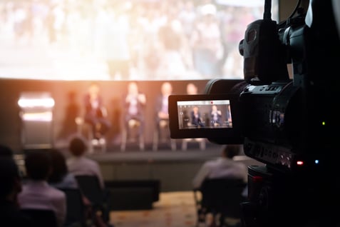 Camera recording a live panel event, illustrating professional video production for webinars and presentations.
