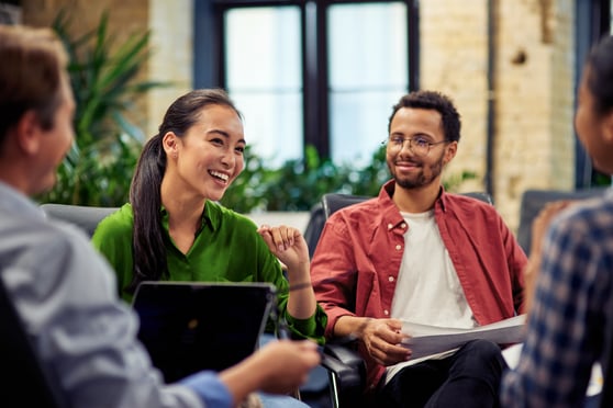 Young cheerful business woman discussing project results with colleagues while working together in the modern office