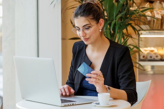 Woman shopping online with a credit card while reviewing Amazon AI listing optimisation tips