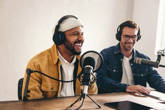 Two podcasters recording audio content, highlighting podcasting in a guide to content marketing approach.