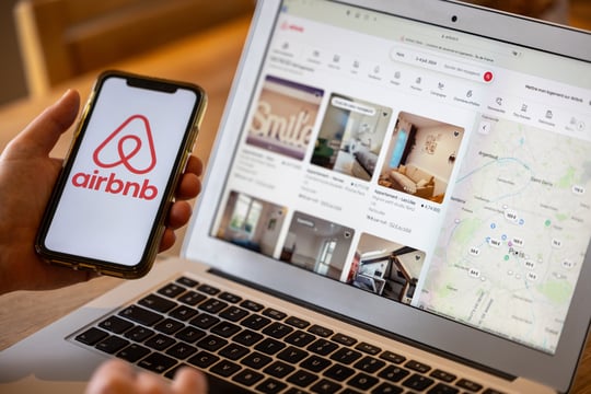 Airbnb app on phone and laptop showing experiential marketing and brand storytelling.