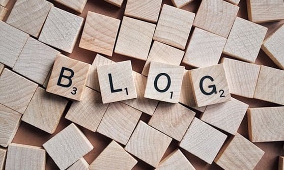 Content marketing examples with the word 'BLOG' displayed using wooden Scrabble tiles.