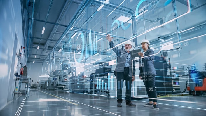 Two engineers in a smart factory showing how AI in manufacturing enhances productivity.